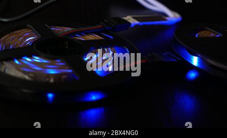 Diode strip for decoration of interiors. Led lights tape. Blue color on dark Stock Photo
