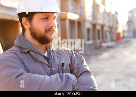 Portrait of construction manager and builder wearing hardhat. Stock Photo