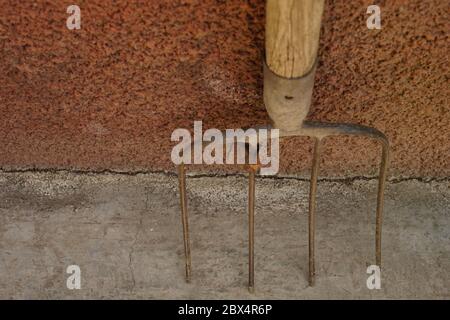 old pitchfork stand on the stone floor, top view, close-up Stock Photo