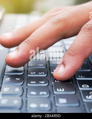 close up of a hand typing on a keyboard Stock Photo