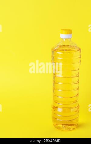 Plastic bottle with vegetable oil on a yellow background. Copy space Stock Photo