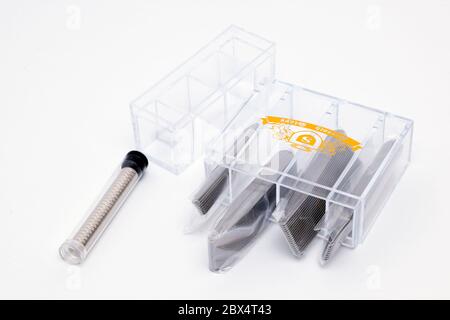 Plastic Containers Containing Magnetic Metal Collar Stiffeners of different Sizes on a white background Stock Photo