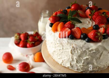 Composition with delicious berry cream cake against brown background. Tasty dessert Stock Photo