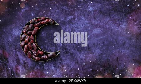 Dates in a moon shaped plate Islamic Iftar and Eid Al Adha concept background, colorful dates image decorated with  shape of crescent moon Stock Photo