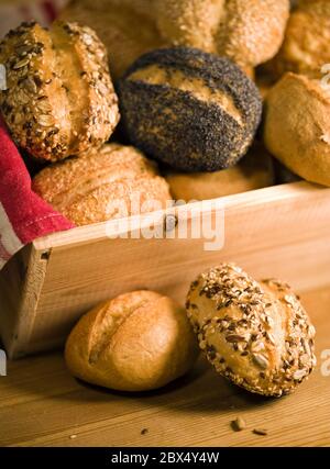 detail of old bakery, various rolls with different seeds in wooden box with towel Stock Photo