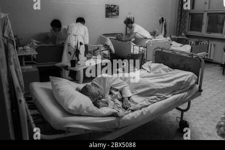 Berlin / Prenzlauer Berg / Health / GDR / 3 / 1990 Old woman in Prenzlauer Berg hospital, ward for chronically ill patients. There are 8 beds in the room. Nurses. // Seniors / Care / Old People / *** Local Caption *** East Germany / Communist Germany / Health Hospital in Prenzlauer Berg, Quarter of East Berlin. [automated translation] Stock Photo