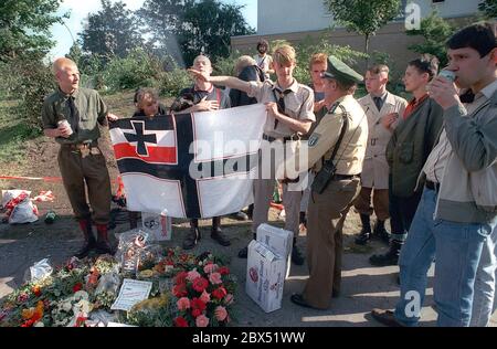 Berlin-Spandau / Nazis / right wing groups 20.8.1987 In front of the war criminals' prison in Spandau, Rudolf Hess has just died. The right-wing groups are gathering in mourning. Young right-wing radical Michael Wendt (right) with the Reich war flag and the Kuehnen salute, a variation of the Hitler salute, which was banned. A policeman inquires what this is all about. Flowers in front for Hess. // Nazi / Fascism / *** Local Caption *** The Prison for war criminals in Berlin-Spandau. The last prisoner, Rudolf Hess, just died after 46 years in the prison shown in the background. Right wing Stock Photo