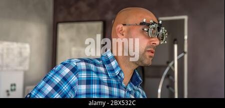eye examination by optometrist at clinic, young man as patient Stock Photo