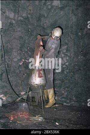 Thuringia / GDR / Economy / 1990 Uranium mining in Drosen near Ronneburg, 600 meters depth. Blasting is prepared in the tunnel to crush the rock. A blaster prepares the blasting. In December 1989 uranium is still being mined. The company belonged to the VEB Wismut // Environment / Mining / Radiation / The German-Soviet corporation was founded after the formation of the GDR, in order to enable the Soviet Union to continue to have access to uranium in the Erzgebirge. From 1946 to 1990, more than 200,000 tons of uranium ore were mined. When uranium mining was stopped in 1990, huge areas of Stock Photo