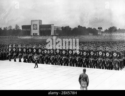 View of the parade of SA standard-bearers to the Ehrenhalle in the Luitpoldarena during the great roll call of SA, SS, NSKK and NSFK. In the background at left is the Luitpoldhalle decorated with swastika flags. Stock Photo