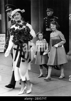 Elizabeth II (right) leaves the opening ceremony of the Coronation Royal Tournament in Olympia, London, accompanied by Queen Elizabeth (left) carrying a large bouquet of flowers, King George V and Princess Margaret Rose (centre). Stock Photo