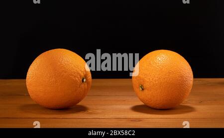 Two oranges on wooden table and black background Stock Photo