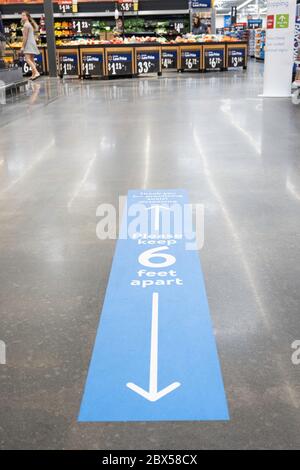 Vidalia, Georgia / USA - May 4, 2020: Walmart’s social distancing policy applied and implemented as floor sign, marker, and reminder. Stock Photo