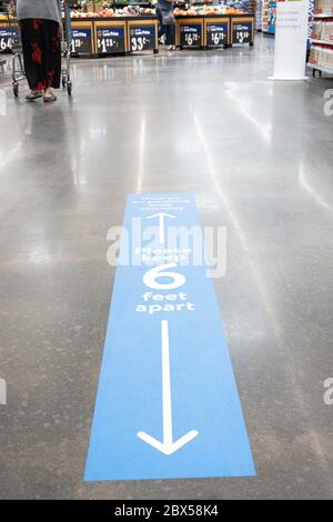 Vidalia, Georgia / USA - May 4, 2020: Walmart’s social distancing policy applied and implemented as floor sign, marker, and reminder. Stock Photo