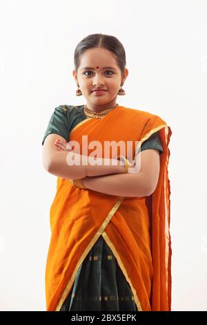 Young girl standing in front of a white background. Stock Photo