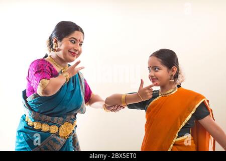 Young bharatnatyam dancer learning mudra and expressions from her teacher. Stock Photo