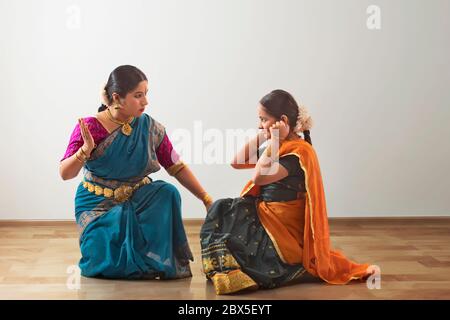 Bharatnatyam dancer performing an act with her student. Stock Photo