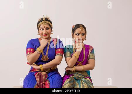 Bharatnatyam dancer and her student performing gracefully through their eyes and expressions. Stock Photo