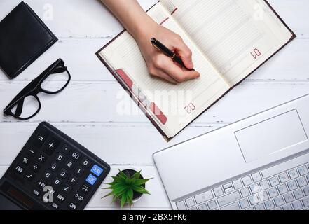 The human hand writes down plans for current affairs in daily diary Stock Photo
