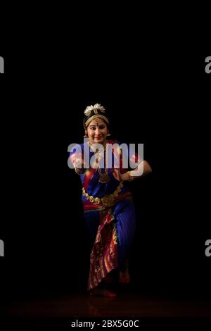 Bharatnatyam dancer performing in front of a dark background. Stock Photo