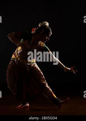 Bharatnatyam dancer performing in front of a black background. Stock Photo
