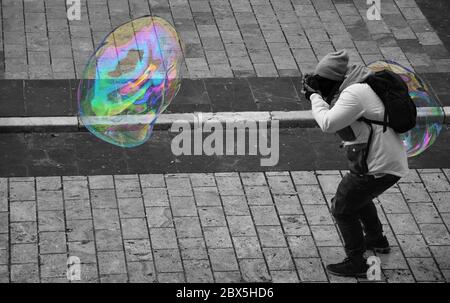 Man taking pictures of a large soap bubble Stock Photo