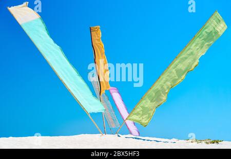 Multicolor flags over blue sky background on sunny day Stock Photo