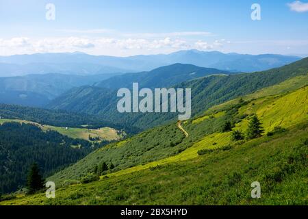 summer mountain landscape. green hills rolling in to the distance. fluffy clouds on the blue sky above the valley. bright sunny day