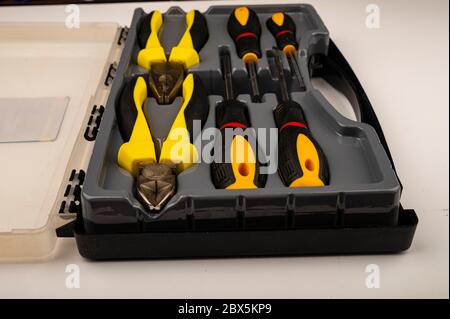 Various screwdrivers and pliers in a plastic case. Close up. Manual locksmith and installation tools for home work Stock Photo