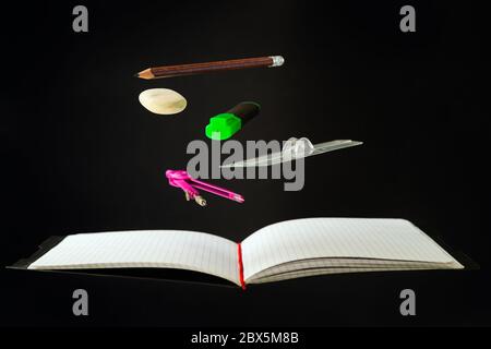 Levitating school supplies for math - notebook, pen, ruler, pencil, divider and eraser on black background. Concept of education and creativity Stock Photo