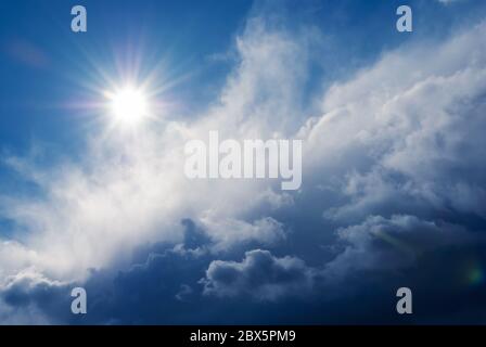 sun shining above beautiful stormy clouds, sky is clearing after rain Stock Photo