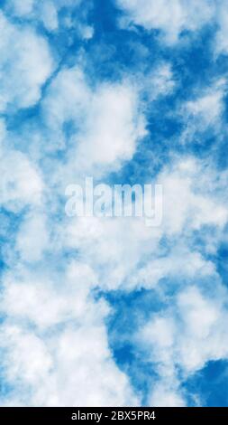 wispy white summer clouds in azure blue sky Stock Photo