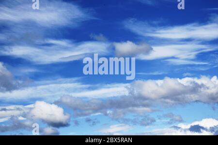 White and grey cloud formations against vivid blue sky on a summer day Stock Photo