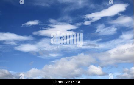 White and grey cloud formations against vivid blue sky on a summer day Stock Photo