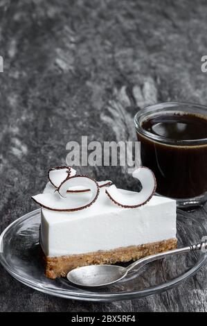 Homemade  cheesecake decorated with fresh coconut flakes on rustic wooden table Stock Photo