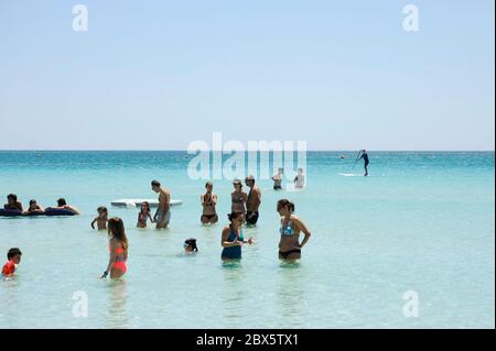 Bathers having fun and swim in the clear transparent waters of the sea - Summer holiday concept in idyllic beach - People enjoying life Stock Photo