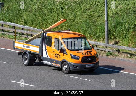 QTS 2019 orange Ford Transit 350;  Haulage delivery trucks, lorry, transportation, truck, cargo carrier, dropside vehicle, European commercial transport industry HGV, M6 at Manchester, UK Stock Photo