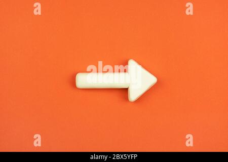 The white arrow on the red background. 3D mockup.  A hint pointing direction. Right way concept. Stock Photo