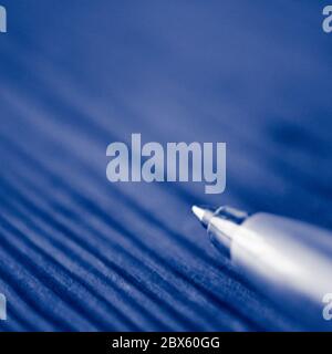 Ball pen on the wooden table. Macro photo. Copy space. Blue tone Stock Photo