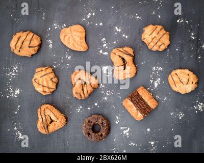 Top view of assorted sweet biscuits and cookies on a gray background with icing sugar. Stock Photo