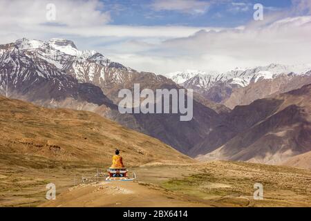 A scenic view of the statue of Buddha facing the Himalayan mountains surrounding the village of Langza in the Spiti Valley. Stock Photo