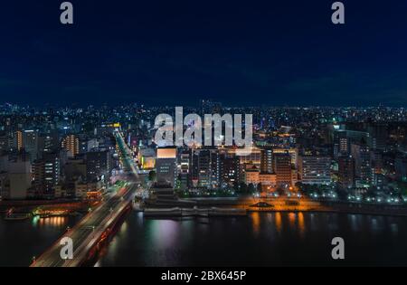 tokyo, japan - march 25 2020: Aerial nocturn panoramic view of the Azumabashi bridge on Sumida river leading to the illuminated buildings and skyscrap Stock Photo