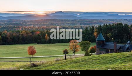 rising sun lights up  Camels Hump Mountain and the Champlain Valley  at Shelburne Farms  historic Barn Stock Photo