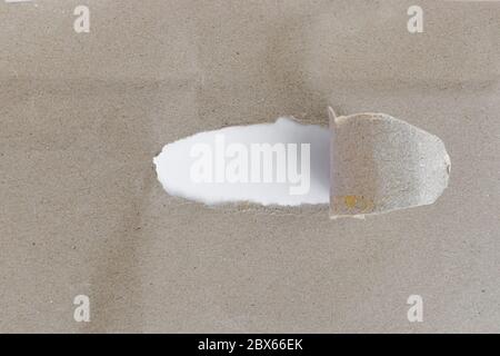 Torn brown paper with opening showing white background Stock Photo