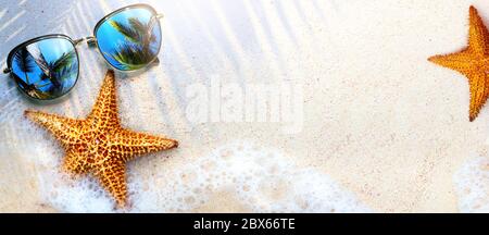 Art Summer Beach background with sunglass and starfish on sand; Tropical sea vacation concept Stock Photo