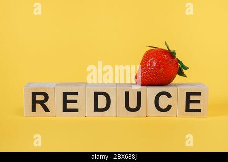 REDUCE Word Written on Wooden Cube. Concept Stock Photo