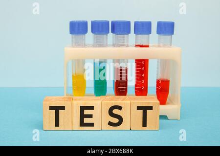 TEST word written on wooden cubes on a blue background. Medical concept Stock Photo