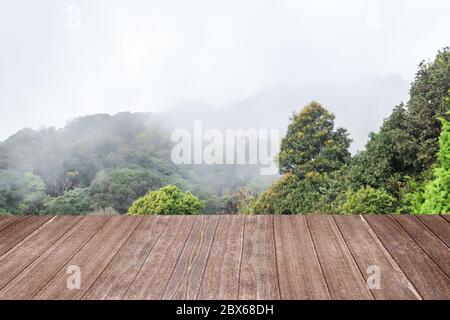 Wooden table light brown color with of mountain and fog a background. For montage product display or design key visual layout. Stock Photo