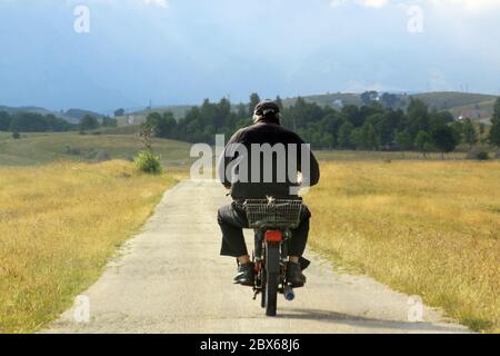 Local man on moped on Durmitor mountains ring road, Montenegro in summer Stock Photo