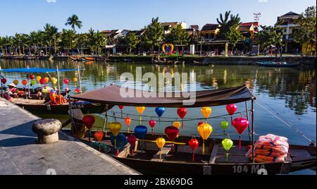 boats with lanterns docked at river in old town of Hoi An ready to take tourists on boat trip Stock Photo